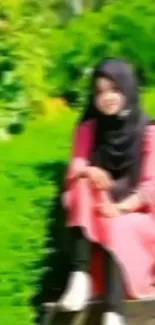 Blurred woman in a pink dress sitting in a lush green garden.