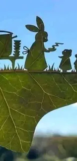 Silhouette of animals crafted into a green leaf against a sky background.