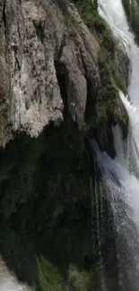 Tranquil mobile wallpaper with waterfall and lush greenery.