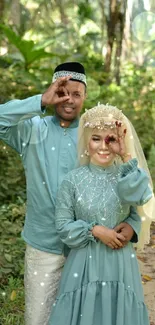 Happy couple in traditional attire amidst a lush forest scene.