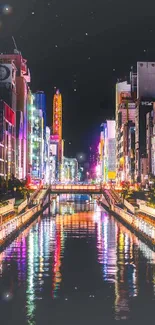 Vibrant cityscape with neon lights reflecting on a canal at night.