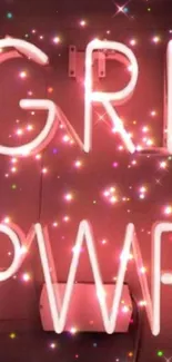 Neon 'Girl Power' sign with sparkles on a pink background.