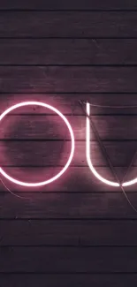 Neon letters glow against a dark wood background.