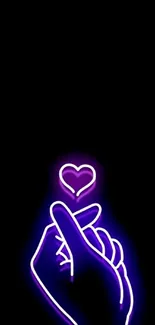 Neon heart hand art on black wallpaper.