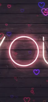 Neon love and heart design on dark wooden background.