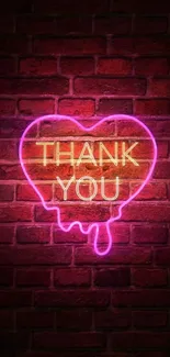 Neon heart with 'Thank You' on brick wall in vibrant pink glow.