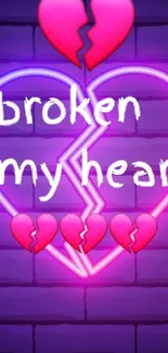 Neon broken heart graffiti on a brick wall.