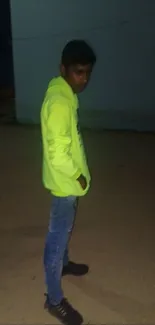 Person wearing neon hoodie in urban night setting.