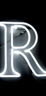 Neon letter R glowing against a black backdrop.