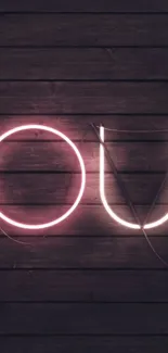 Neon letters 'YOU' on dark wood background.