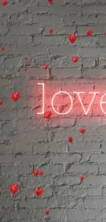 Neon pink 'love' sign on gray brick wall background.