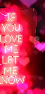 Neon sign with love quote glowing on a vibrant pink background.