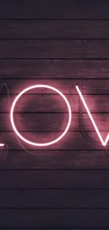 Pink neon love sign on dark wooden background wallpaper.