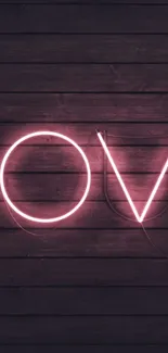 Neon 'LOVE' sign on wooden background, glowing softly.