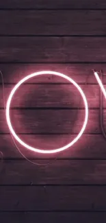 Neon pink love sign on a wooden wall.