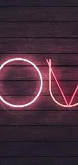 Neon love sign on dark wooden background.