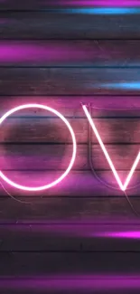 Neon 'LOVE' sign glowing on a rustic wooden background.