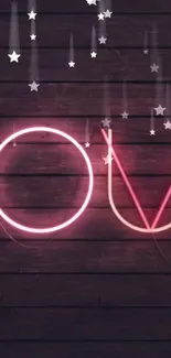 Neon sign with 'Love' in pink and stars on a dark wood background.