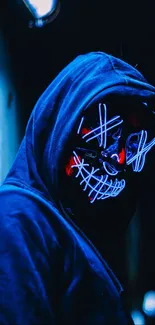 A hooded figure with a neon mask in a dark setting, emitting a blue glow.