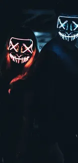 Two individuals wearing neon masks in the dark.