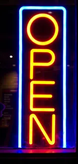 Bright neon "Open" sign with red and blue colors on black background.