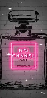 Neon pink Chanel perfume bottle on a brick wall.