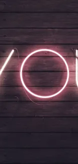 Neon pink 'You' sign on dark wooden wall.