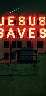 Neon 'Jesus Saves' sign on city building at night.