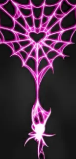 Neon pink spider web wallpaper with heart center on a dark background.