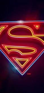 Bright neon Superman logo on dark background with red and blue hues.