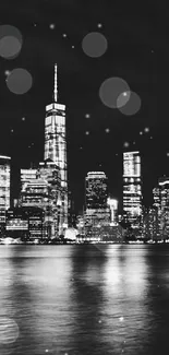 Black and white NYC skyline reflecting on water at night.