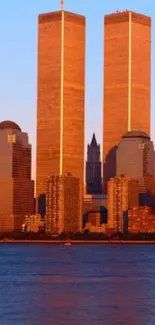 New York skyline with Twin Towers at sunset in warm orange hues.