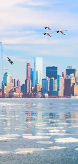 New York skyline with birds over icy waterfront.