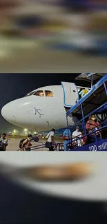 Passengers boarding a plane at night with airport lights in the background.