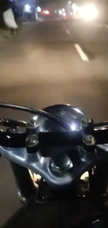 Motorbike riding on a dimly lit city street at night.