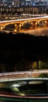 Bridge over water with city lights at night.