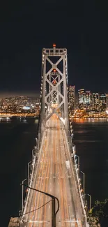 Nighttime city view with a lit bridge leading into the skyline.