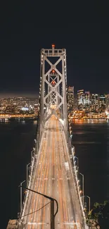 Night view of illuminated city bridge with urban skyline in the background.