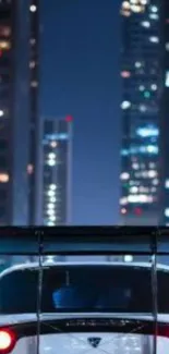 Car driving at night in a city, surrounded by illuminated skyscrapers.