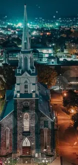 Lit church in cityscape at night with vibrant teal lights.