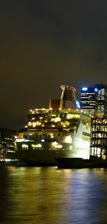 Lit cruise ship by night city skyline reflecting on water.