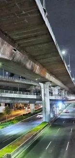 Nighttime view of a city highway under overpasses.