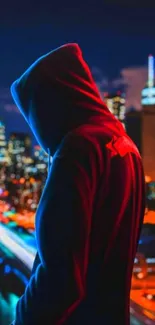 Hooded silhouette in vibrant cityscape at night with neon lights.