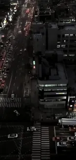 Aerial view of a busy city street at night with lights and traffic.