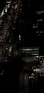 A lively night city view with glowing street lights and traffic from above.