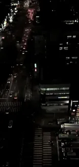 Aerial view of a city street at night with glowing lights and traffic.