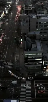 Aerial view of a bustling city street at night with city lights glowing.