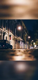 Night view of a quiet city street with vintage cars under glowing streetlights.