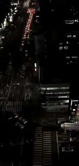 Aerial view of city streets at night with vibrant lights and traffic.