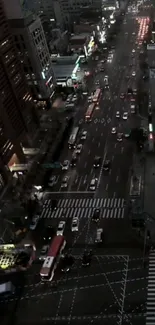 Aerial city view of bustling night street with lights and traffic.